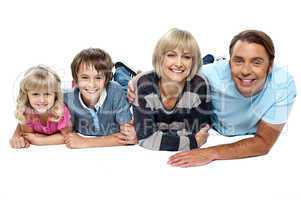 Smiling family of four relaxing on white background