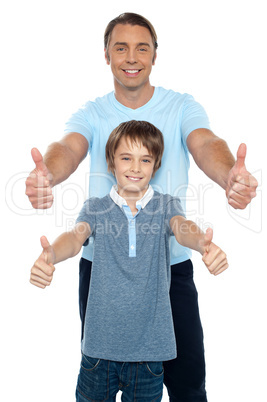 Handsome father and son showing thumbs up to camera