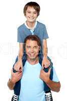 Adorable young son enjoying piggyback ride