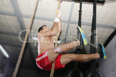 Crossfit rope climb exercise.  Focus in the body.