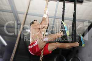 Crossfit rope climb exercise.  Focus in the body.