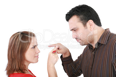 Young couple pointing at each other against a white background