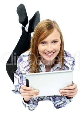 Girl relaxing on studio floor and browsing her new tablet