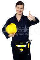 Woman in builder uniform showing thumbs up