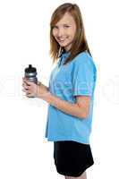Girl holding sipper bottle. Break from gym workout