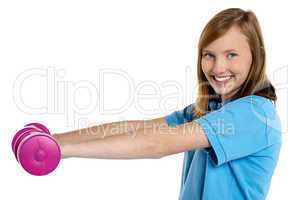 Young fit girl exercising with pink dumbbells