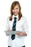 Cheerful student in school attire using tablet pc