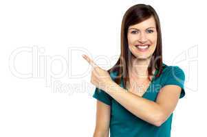 Attractive lady pointing towards copy space area