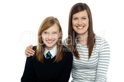 Mom posing with arms around her cute daughter