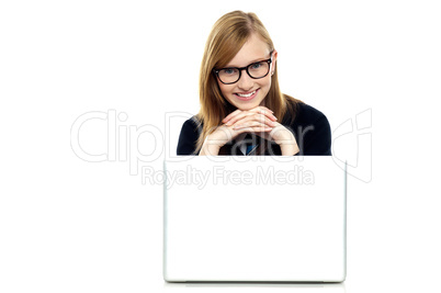 Charming schoolgirl sitting with her laptop open