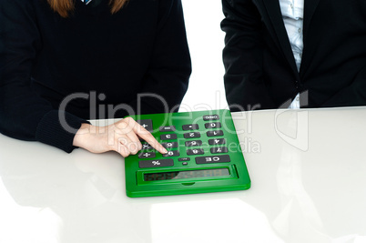 Cropped image of teacher and a student operating calculator