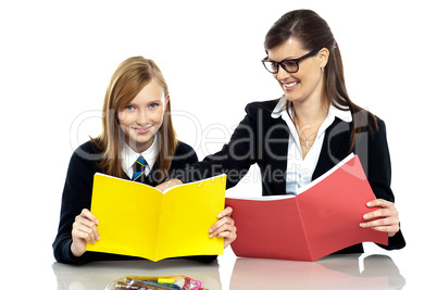 Educator sitting with a student and taking her through a lesson