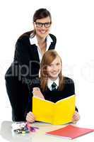 Teacher instructing student and helping her