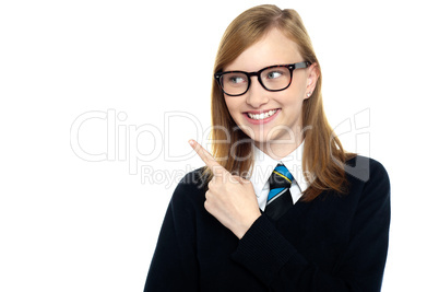 Bespectacled smiling student pointing away