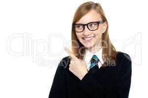 Bespectacled smiling student pointing away