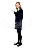 Student standing sideways and pointing forward