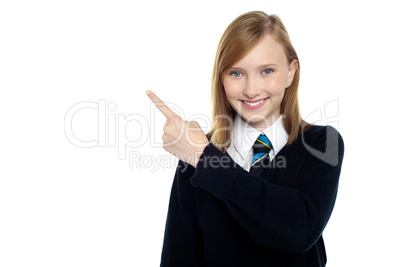 Calm and relaxed teen girl pointing sideways