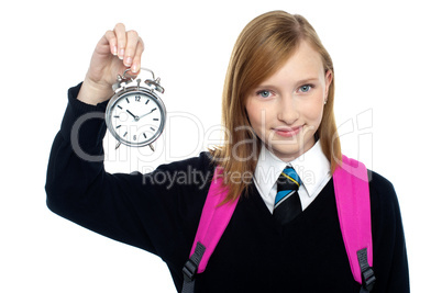 Pretty charming schoolgirl holding time piece