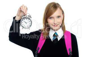 Pretty charming schoolgirl holding time piece