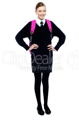 Confident schoolgirl posing with hands on waist