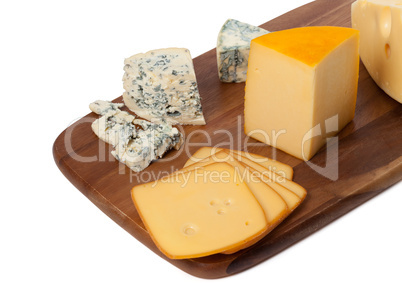 Different types of cheese on wooden kitchen board