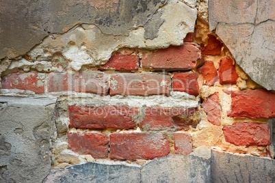 Old brick wall with destroyed stucco