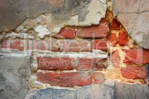 Old brick wall with destroyed stucco