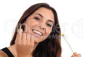 Teen girl defoliating a daisy smiling