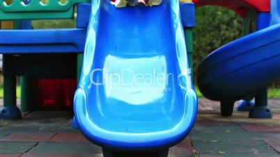 Cute little girl, outside in summer, playing on a slide.