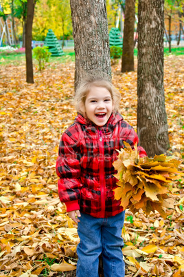 Little girl in a red jacket with leaves