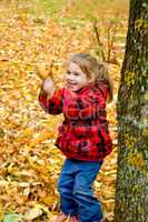 Little girl playing with leaves