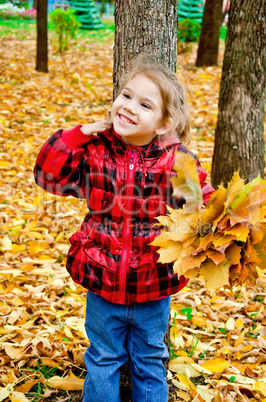 Little girl with a bouquet of yellow maple leaves