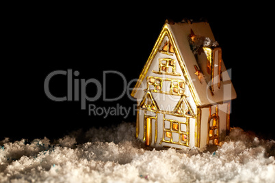 Little toy house covered with artificial snow.