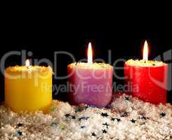 Three candles with artificial snow.