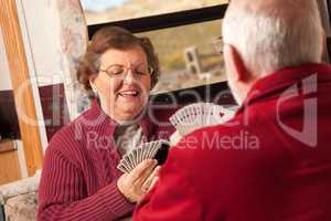 Happy Senior Adult Couple Playing Cards in Their Trailer RV