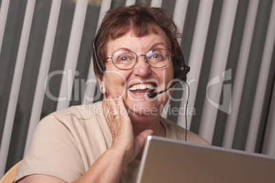 Smiling Senior Adult Woman with Telephone Headset and Monitor