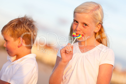 Cute Little Girl and Brother Enjoying Their Lollipops