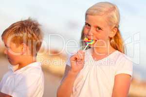 Cute Little Girl and Brother Enjoying Their Lollipops