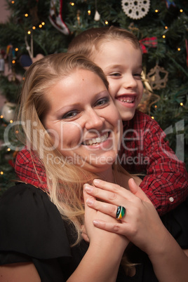 Adorable Son Hugging His Mom in Front Of Christmas Tree