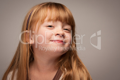 Fun Portrait of an Adorable Red Haired Girl on Grey