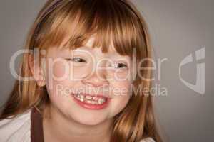 Fun Portrait of an Adorable Red Haired Girl on Grey