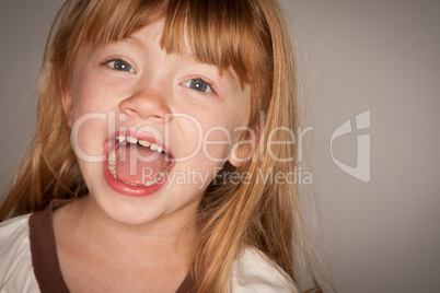 Fun Portrait of an Adorable Red Haired Girl on Grey