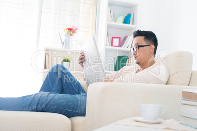 Asian man reading news paper