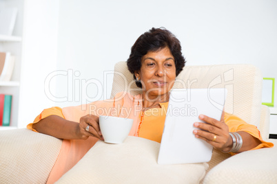 Mature Indian woman using computer tablet