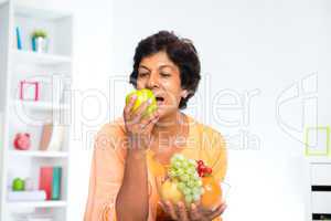 Mature Indian woman eating fruits