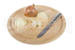 Zwiebel mit Messer auf Holzteller