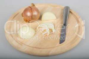 onion and knife on a wooden board
