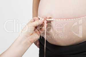 hand of midwife measuring pregnant belly