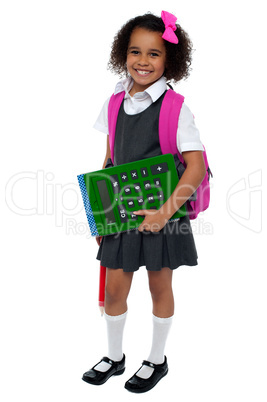 Smart young school girl showing large green calculator