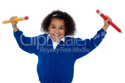 Smart young school girl showing pencils